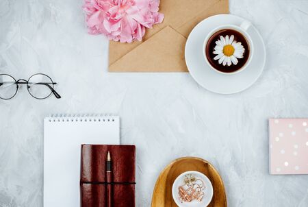 Feminine business mockup with stationery supplies, daisies, peony flower, notebooks and glasses, flatlay on cement backgroundの写真素材