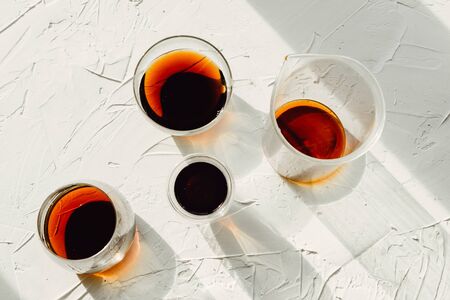 Three cups of fresh brewed coffee and glass cup on white cement background