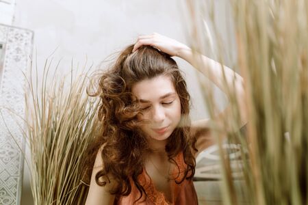 Young brunette woman shaking head and lipping her hair, selective focusの写真素材