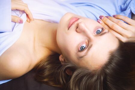 Closeup of young beautiful woman in blue lying in bed. Natural beauty. Selective focus. Film styleの写真素材