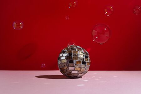 Disco ball on pink background with soap buble around, selective focusの写真素材