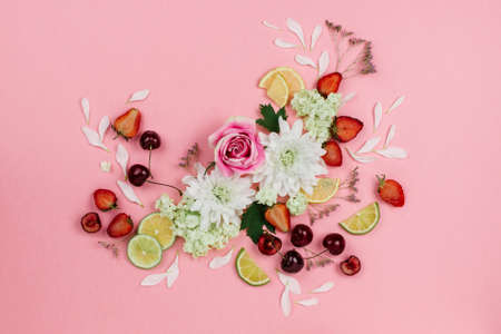 Beautiful flatlay of various fruits, berries and flowers on pinkの写真素材