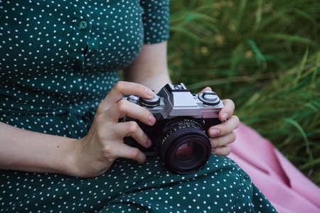 Closeup of woman's hands holding film vintage camera
