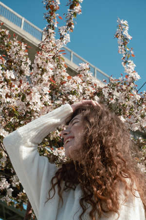 Young brunette woman laughing in front of apple tree