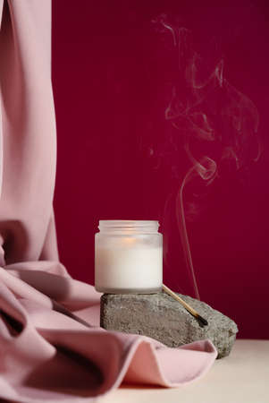 Soy candle with smoking match on cement rock,の写真素材