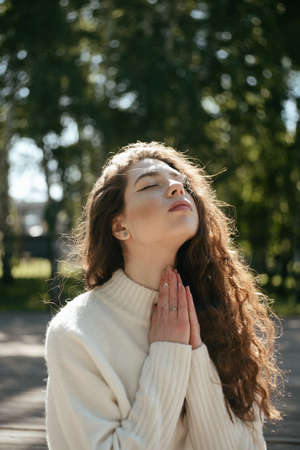 Young brunette woman meditating outdoors with her eyes closedの写真素材