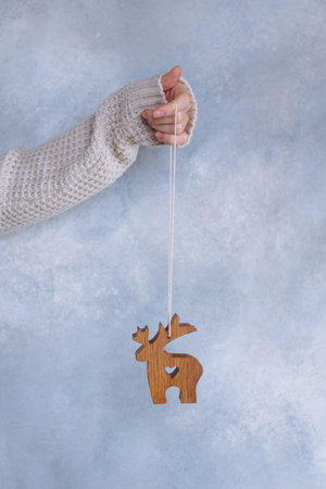 Wooden toy deer in female hands, sustainable Christmas ornamentの写真素材