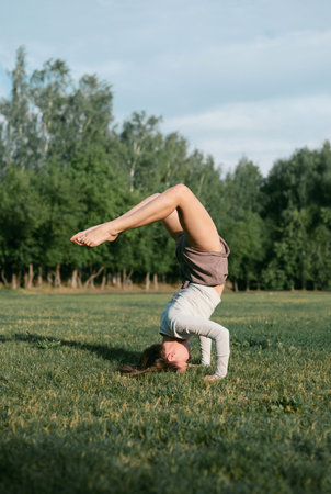 Adult female practising yoga outside, forearm balance poseの写真素材
