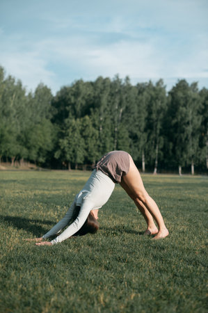 Adult female practising yoga outside in crop top and linen shorts