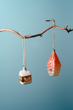 Old vintage Christmas glass house ornaments on a branchの写真素材