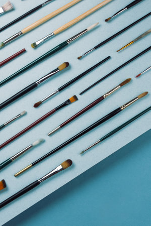 Top view of various painting brushes on blue background.の写真素材