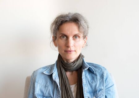 Portrait of middle aged woman with grey hair, denim shirt and scarf