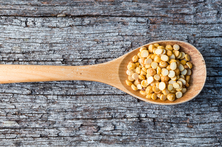High angle view of dal in a wooden spoon on an old wooden table (close up and cropped)の写真素材