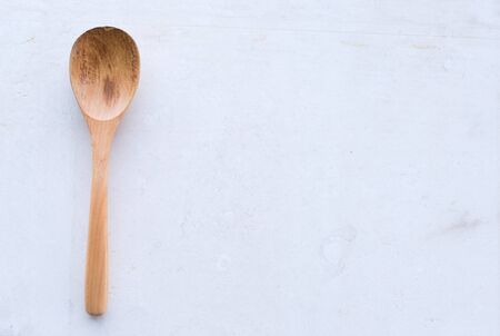 High angle view of rustic wooden spoon against an imperfect white limestone backgroundの写真素材