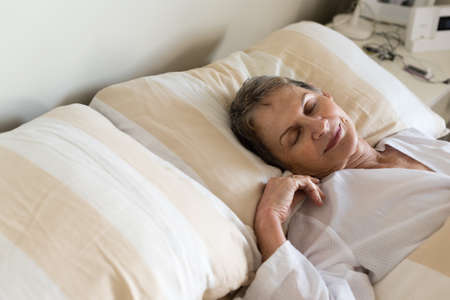HIgh angle cropped view of elderly woman sleeping in bed (selective focus)の写真素材