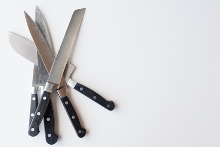 High angle view of kitchen knives on white table with copy space to rightの写真素材