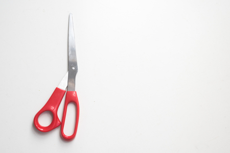 High angle view of red scissors on white background with copy spaceの写真素材