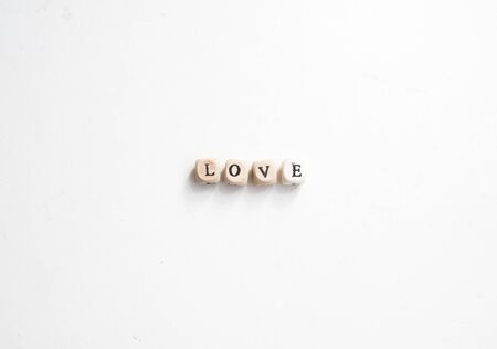 Rustic wooden alphabet blocks spelling LOVE on white background from above