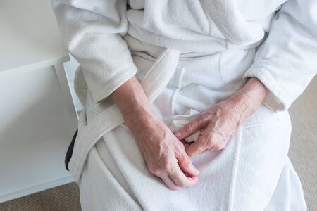 High angle view of older woman's hands holding tissue (selective focus)の写真素材