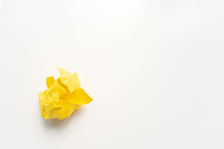 Close up of yellow scrunched up paper on white background with copy spaceの写真素材