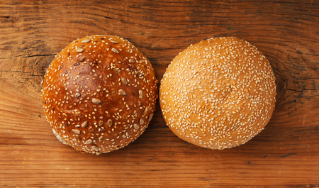 Two hamburger buns on a wooden table. Fast food.の写真素材