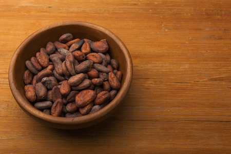 Cocoa beans on old wooden tableの写真素材