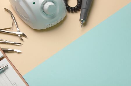 Professional manicure tools on blue and beige background with notebook and pen
の写真素材
