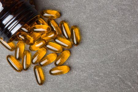 Close up of capsules Omega 3  and a jar on a black backgroundの写真素材