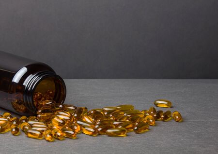 Close up of capsules Omega 3  and a jar on a black backgroundの写真素材