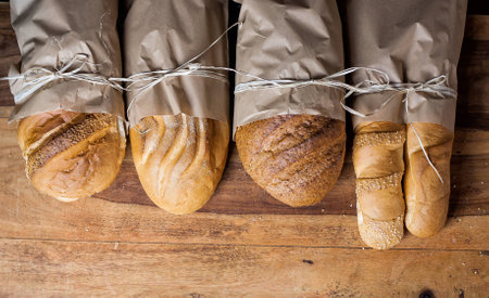 different bread on the wooden table, flour, paper bags, ropeの写真素材
