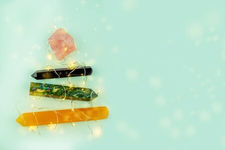 Natural gem geological crystals in a shape of Chistmas tree with lights on mint background, free copy spaseの写真素材