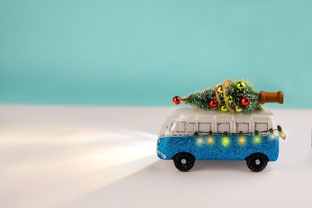 Miniature blue van with lights and a decorated x-mas tree on is top. New Year, Christmas concept.の写真素材