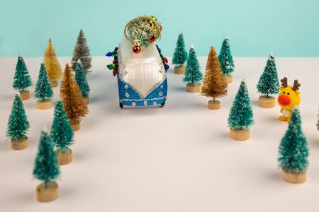Miniature blue van with lights and a decorated x-mas tree on is top. New Year, Christmas concept.の写真素材