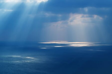 Sunlight through the clouds to the ocean water aerialの写真素材