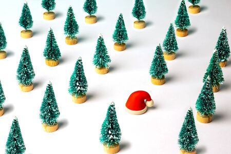 Christmas pattern made with pine trees and small rubber Santa Claus hat. Winter, Christmas, New Year concept.の写真素材