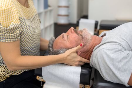 Man having chiropractic back adjustment. Physioterapy, osteopathy, alternative medicine pain relief rehabilitationの写真素材