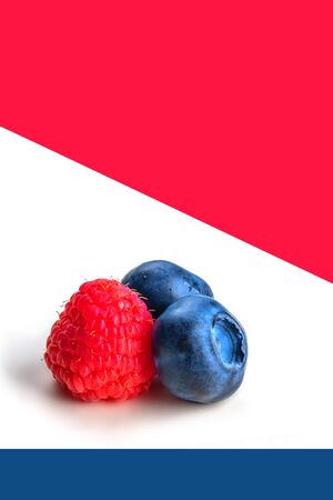 Blueberries and raspberry on white, blue and red background. Close up, top view, high resolution product. Harvest Conceptの写真素材