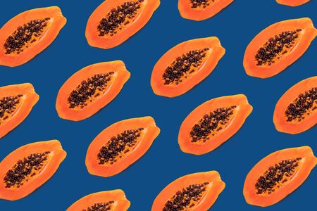 Half of papaya on a blue background, pattern creative designの写真素材