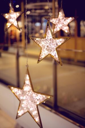 Decorative stars with lights. Christmas background with stars and garland in a city shopping mallの写真素材