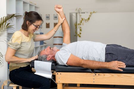 Man having chiropractic back adjustment. Physioterapy, osteopathy, alternative medicine pain relief rehabilitationの写真素材
