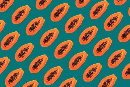 Half of papaya on a green blue background, pattern creative designの写真素材