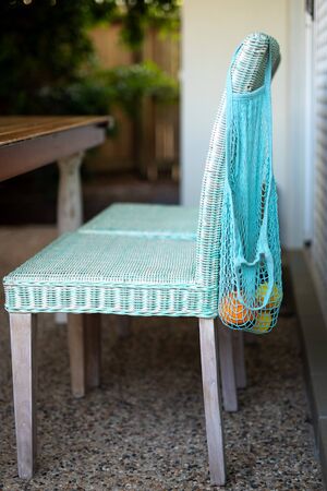 Fruit in blue string mesh reusable bag on the back of chair, zero waste eco conceptの写真素材