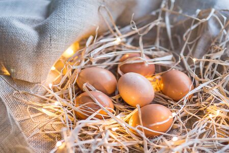 Eggs in sack and straws with lights, Easter conceptの写真素材