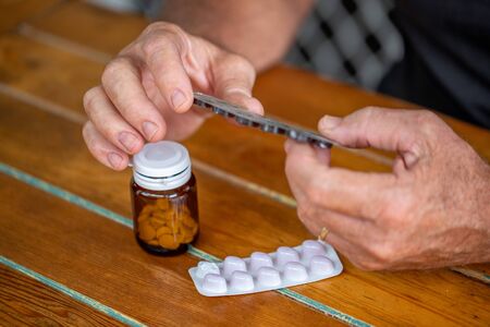 Man holding blister with pills and reading the instructions, medicine concept, targeted focus.の写真素材