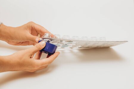 Womans hand taking pills from theeveryday blister pack. Medications for patients in a hospital.