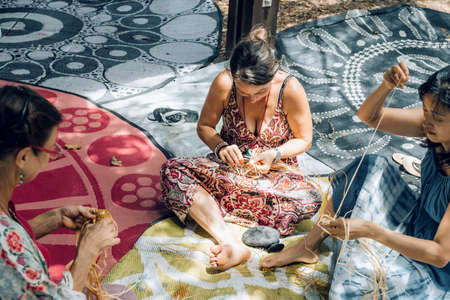 Maroochydore, Australia - February 15, 2020. Females weaving baskets on craft workshop, sitting on...