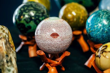 Stone in Sphere shape with a mark like lips on the stand. Various stones minerals gems. Natural background.の写真素材