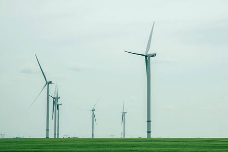 Ecological power with windmill on the field. Wind Turbines and green fields on a cloudy day. Energy...