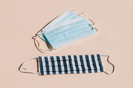 COVID-19. Facial medical and handmade masks on a beige background . Medical masks for protection from viruses and pollution.の写真素材