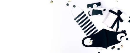 Black and white gift or present boxes, handmade facial masks and confetti on white background. Flat lay composition for birthday, Christmas, wedding. Social distansing.の写真素材